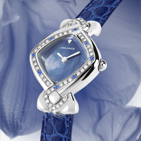 Indira : Montre en acier sertie avec 42 diamants et 8 saphirs, cadran nacre bleue, aiguilles nickelées, cabochon en acier, bracelet en alligator bleu