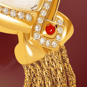 Infinity Gold cascade : Montre en or sertie avec 50 diamants, cadran nacre blanche, aiguilles dorées, cabochon en or avec un rubis, bracelet en brins